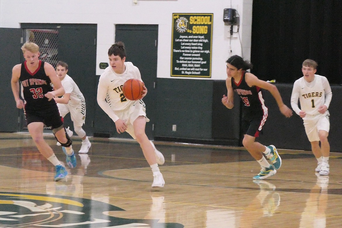 St. Regis sophomore Barrett Bassette (with ball) heads up court past Hot Springs senior Quincy Styles-Depoe during their recent game in St. Regis, won by the host Tigers 48-30. (Chuck Bandel/VP-MI)