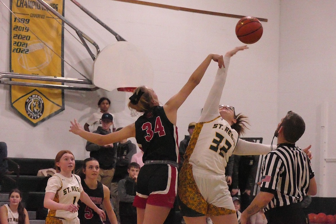 Hot Springs senior Lauryn Aldridge (left, red) and Hot Springs' Amelya Jensen battle for the opening tip-off in their game last week in Hot Springs. (Photo by Chuck Bandel/VP-MI)