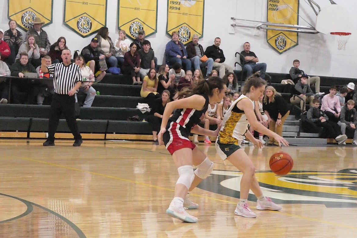 Sophomore guards Kara Chrisensen (left, red) and St. Regis' Shyla Dalka were major players in the recent game between the Lady Heat and the Lady Tigers). (Photo by Chuck Bandel/VP-MI)