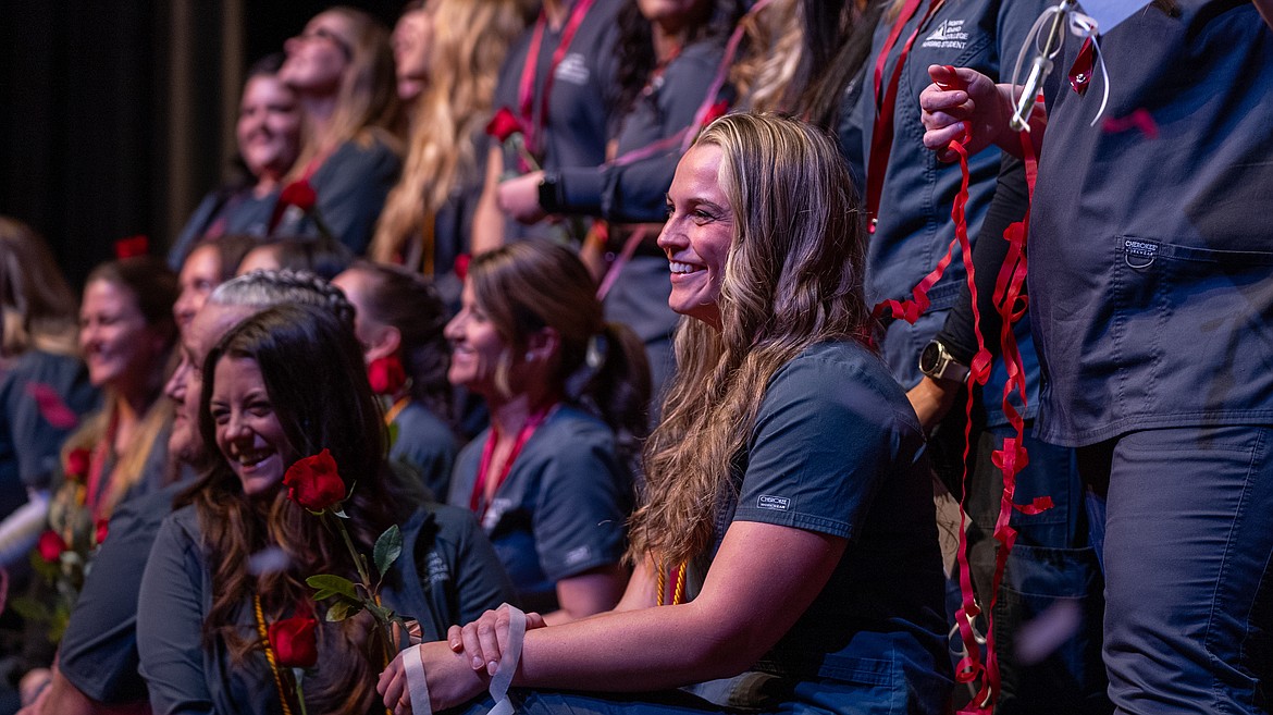 NIC Nursing graduate Jordan Taylor kneels onstage during the NIC nursing program’s pinning ceremony on Dec. 15 in Boswell Hall Schuler Performing Arts Center on NIC’s Coeur d’Alene campus.