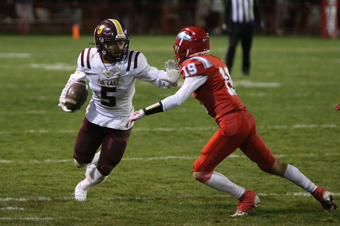 Moses Lake senior Kyson Thomas, left, stiff-arms an Eastmont defender to fight for extra yards.