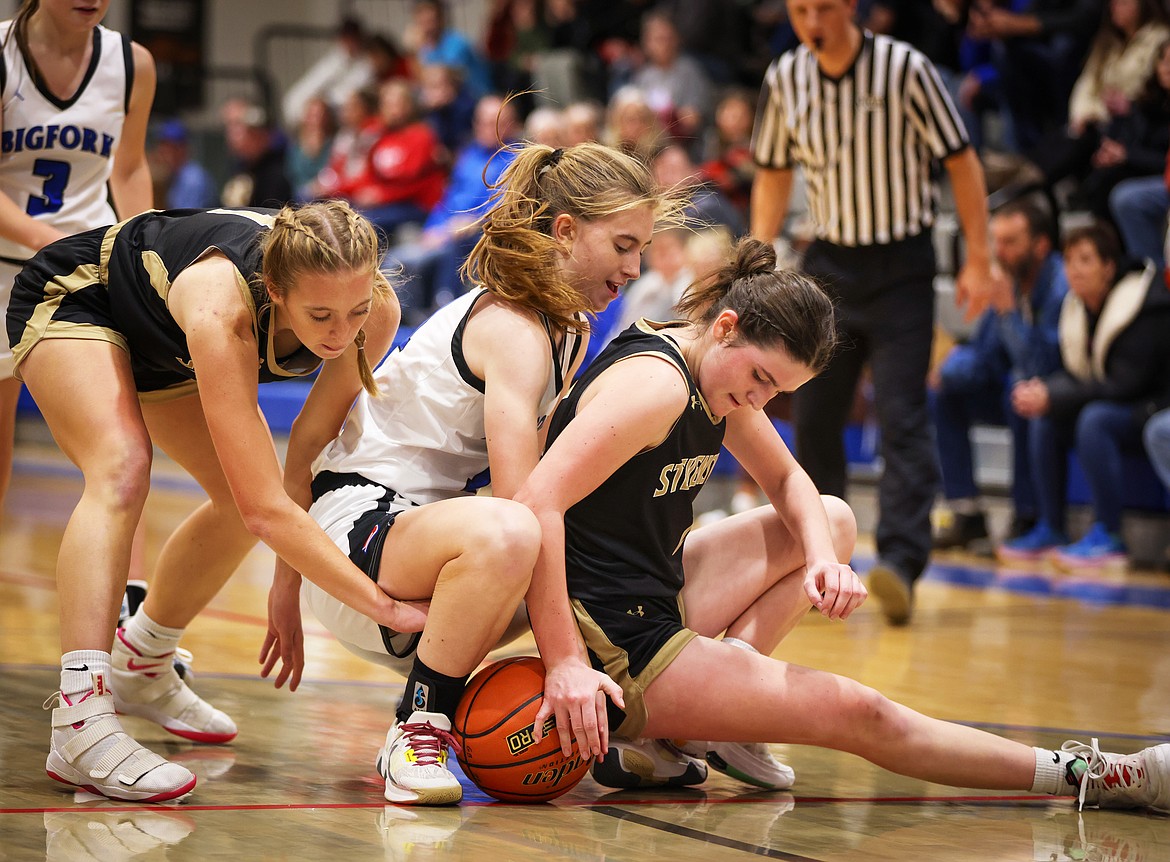 Peyton Benson battles with a pair of Lady Yellowjackets for a loose ball during action against Stevensville in Bigfork Thursday. (Jeremy Weber/Bigfork Eagle)