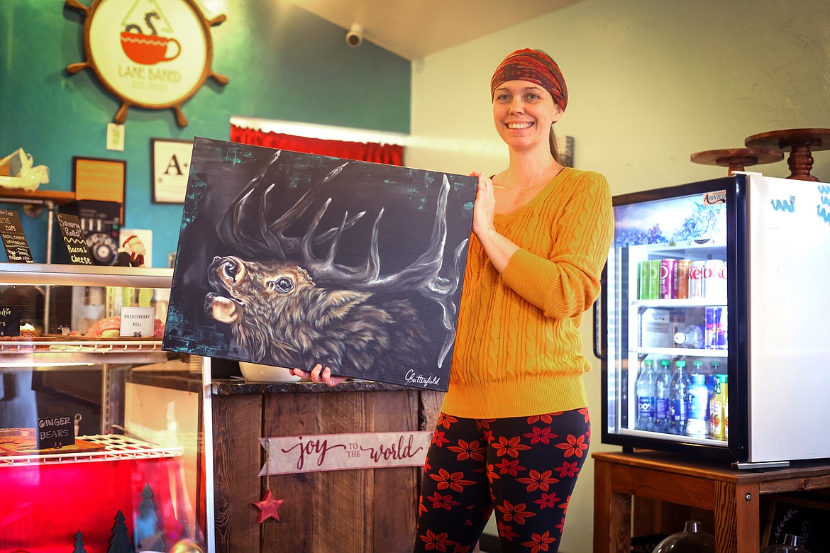 Cassanda Butterfield shows off one of her paintings that is currently hanging at Lake Baked during a busy Thursday morning in December. (Jeremy Weber/Bigfork Eagle)