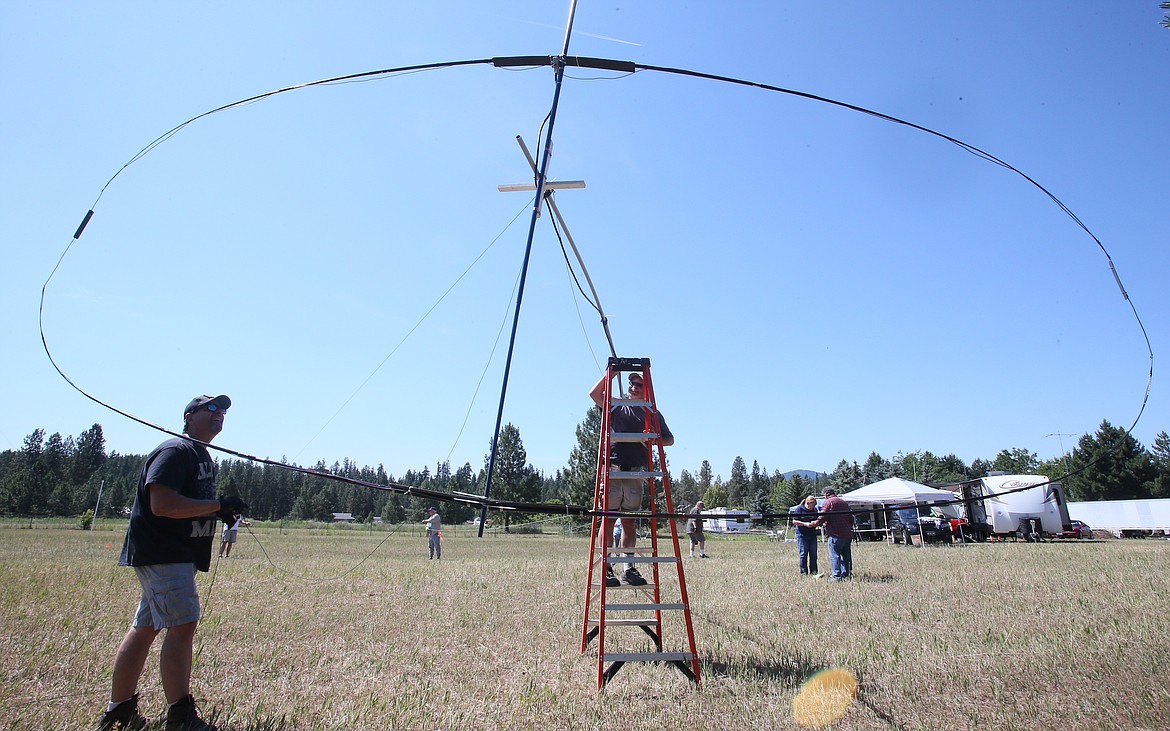Brad Smith, left, and Mark Mayer, center, have a laugh on a sunny June 23 as they and other Kootenai Amateur Radio Society members build the "antenna farm" on Frank Krug's Post Falls property in preparation for Amateur Radio Field Day.