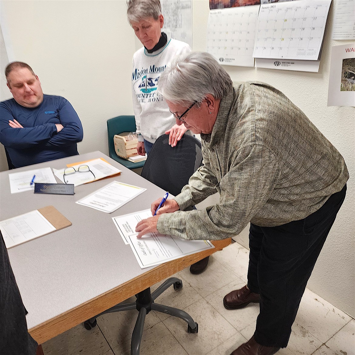 Larry Hall, the new Ward 2 representative on the Ronan City Council, signs official paperwork at last Wednesday's meeting. A longtime resident of Ronan, Hall said he wanted "to contribute a little more time to the community now that I have more time." (Berl Tiskus/Leader)