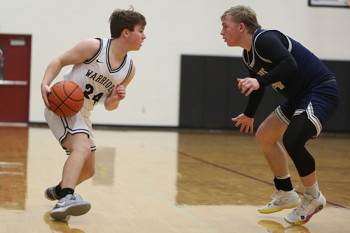 ACH freshman Brady Pitts, left, looks past MLCA/CCS senior Jonah Robertson, right, and toward the rim.