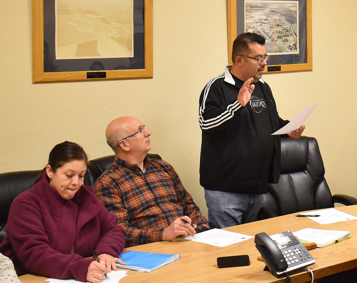 Royal City Council Member Hector Rodriguez, right, takes the oath of office at the council’s Tuesday meeting, as Council Member Perla Garcia, left, and Mayor Michael Christensen look on.