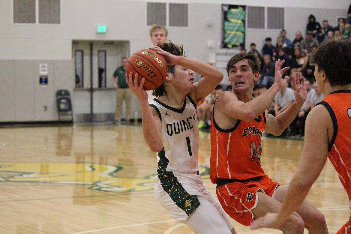 Pierce Bierlink (1) works against the defense of Hans Roberts (14) in Quincy’s Dec. 14 game against Ephrata.