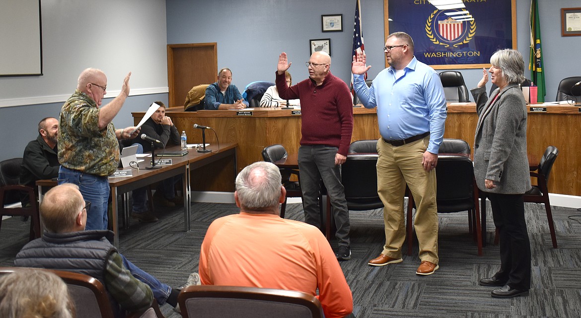 From left: Ephrata Mayor Bruce Reim administers the oath of office to incoming city council members Mike Warren and Beau Lamens and incumbent member Valli Millard