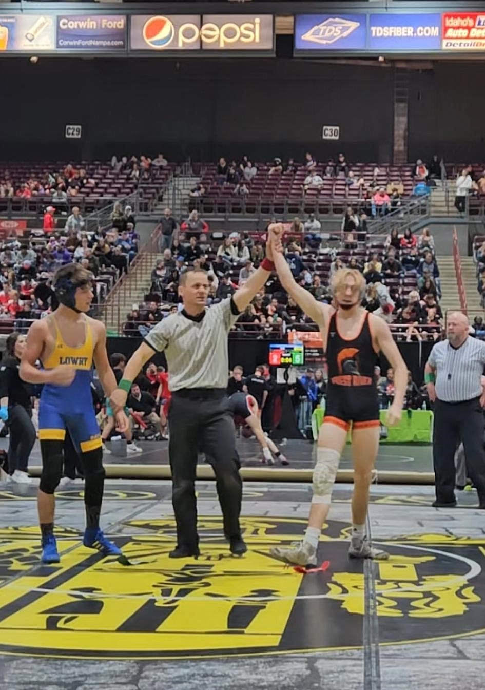 Colm McLaimtaig's hand is raised in the air after defeating Bradyn Snyder of Lowry via pin (1:15) in round one of the Rollie Lane Wrestling Invitational on Friday.