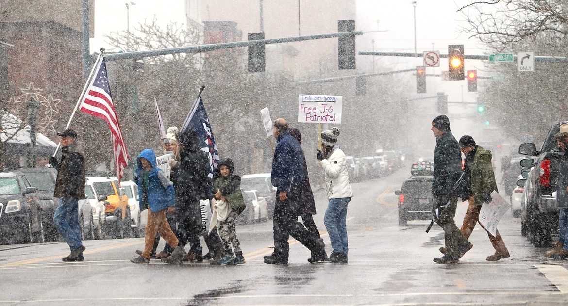 People who participated in a "Justice for J6ers" rally in Coeur d'Alene cross Sherman Avenue on Saturday.