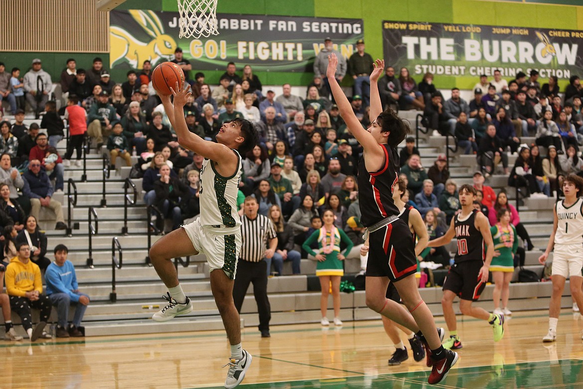 Quincy sophomore Chuy Carrillo, left, scored on a lay-up in the first quarter against Omak. The Jacks found success early in beating Omak’s press, finding open players down the court for baskets.