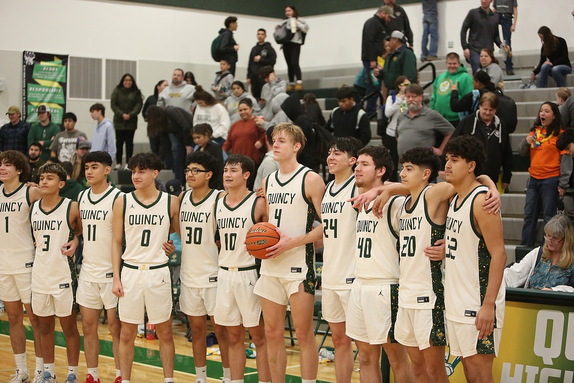 Quincy players gather for photos after the game after senior Aidan Bews (4) scored his 1,000th career point.