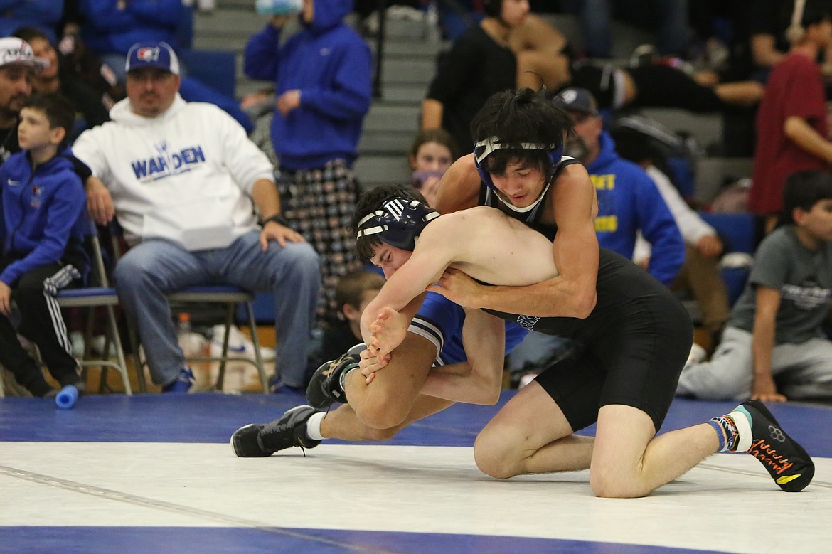 Warden senior Manny Canales, background, was one of eight Cougar wrestlers to place at Saturday’s Jeremiah Schmunk Invitational in Warden.