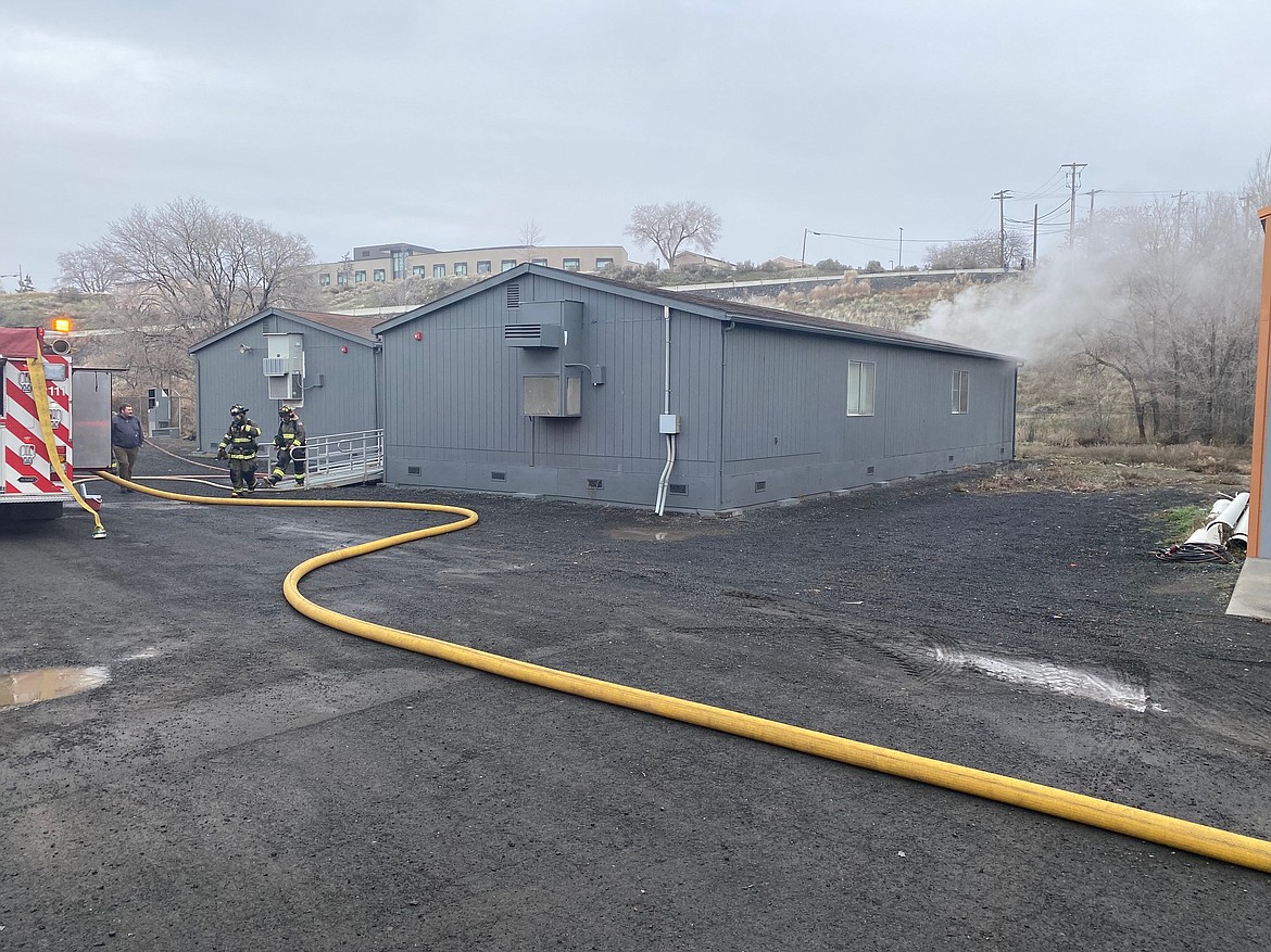 A portable building with two classrooms in it has smoke rolling out of it while firefighters work to put out a blaze that began in the building’s attic on Friday. Ephrata Fire Chief Jeremy Burns said the fire was caused by a malfunctioning air handler.