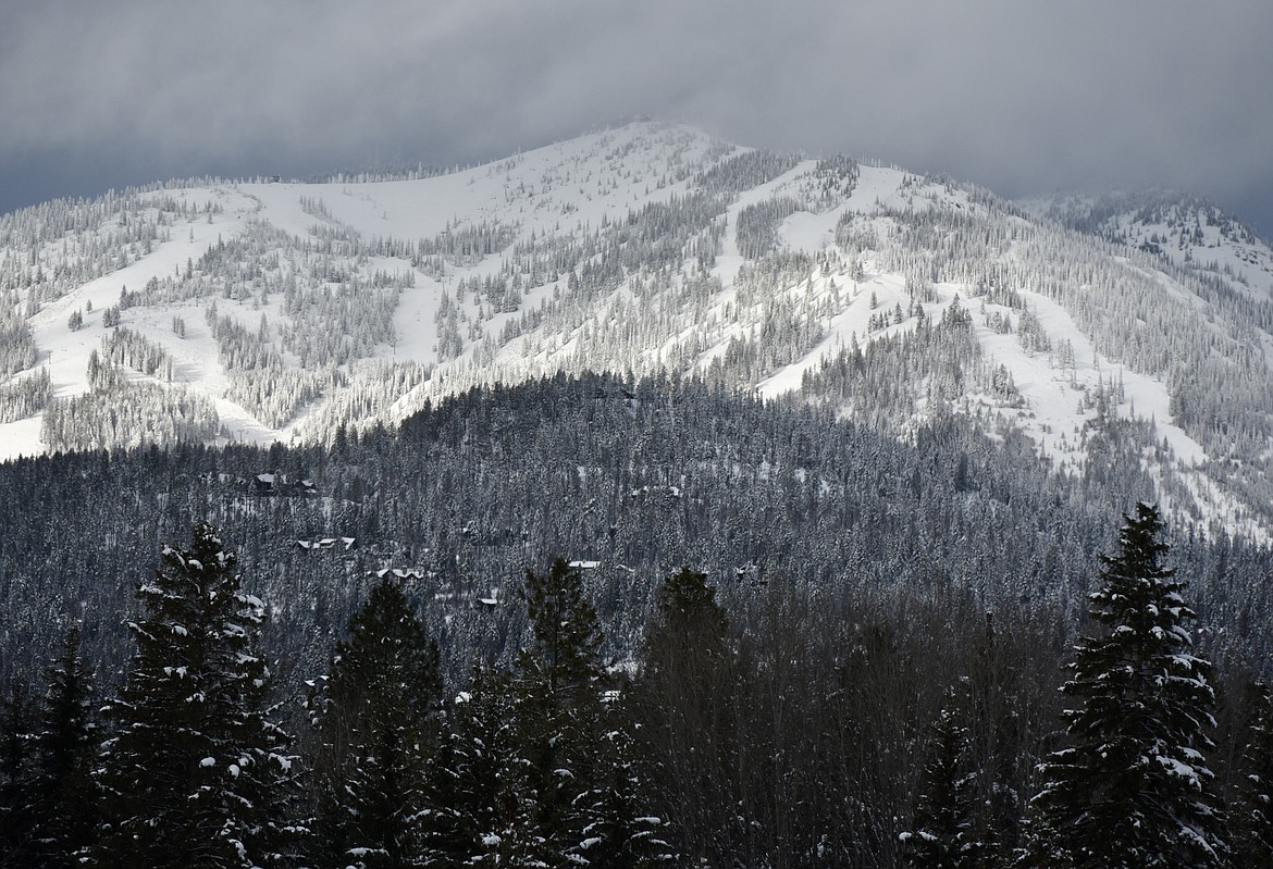 Storm clouds lift to reveal a fresh blanket of snow on Big Mountain near Whitefish on Tuesday, Jan. 9, 2024. About 20 inches of fresh powder has accumulated on Whitefish Mountain Resort over the last week. A winter storm watch is in place through Friday for the Flathead Valley, where heavy snow is possible along with winds gusting as high as 45 mph. Temperatures are expected to rapidly drop well below zero by Thursday. (Matt Baldwin/Daily Inter Lake)