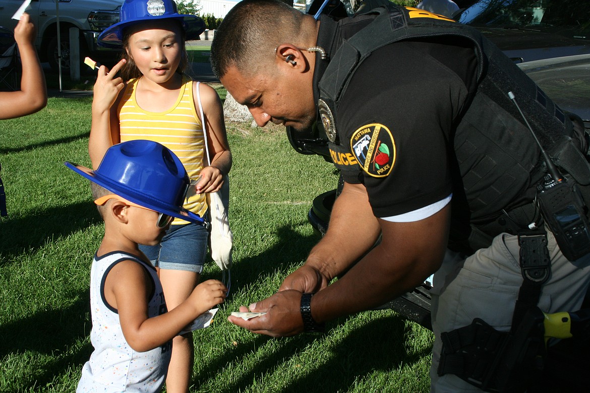 Francisco Araiza of the Mattawa Police Department hands out stickers to children at the 2022 National Night Out. The Project Guardian program, presented at Thursday’s Mattawa City Council meeting, will help Mattawa officers deal with community members, both adults and children, who have special needs.