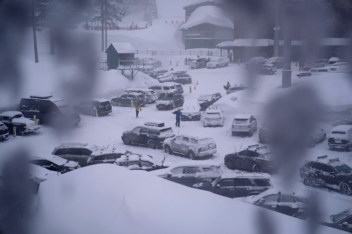 People through the parking area of the Alpine Base Area at Palisades Tahoe during a winter storm Friday, Feb. 24, 2023, in Alpine Meadows, Calif. Search teams were deployed following an avalanche Wednesday at the Palisades ski resort near Lake Tahoe, officials said. (AP Photo/John Locher, File)