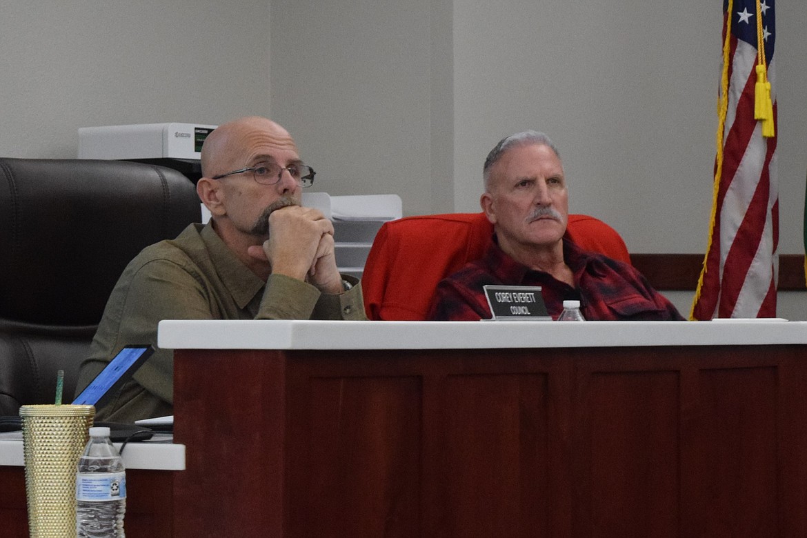 Othello City Council members Corey Everett, left, and John Lallas, right, discuss cargo containers in commercial zones in Othello during Monday’s regular meeting.