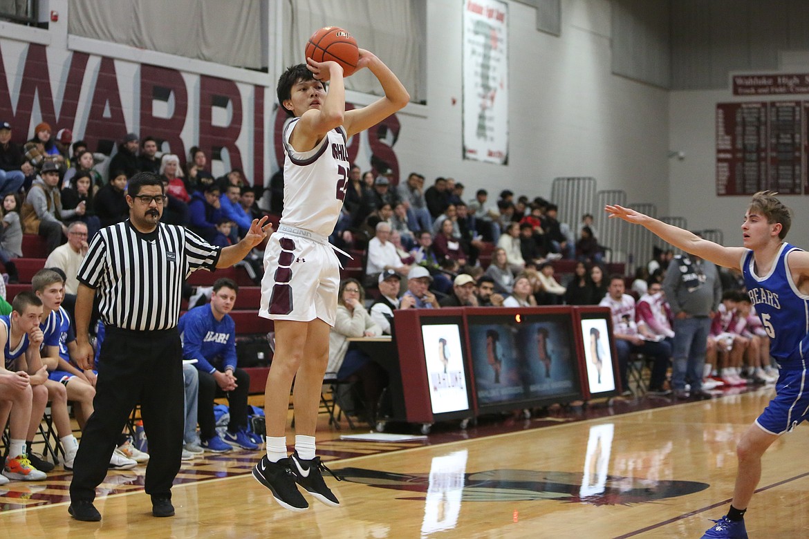 Wahluke junior River Buck, in white, attempts a three-pointer in the first half against Kiona-Benton.