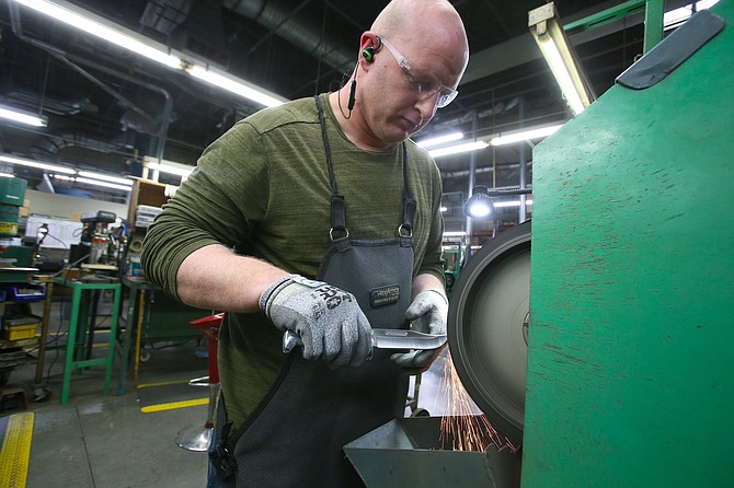 Lukky Carr edges a knife at Buck Knives in Post Falls. Established in San Diego in 1902, the company moved to North Idaho nearly 20 years ago.
