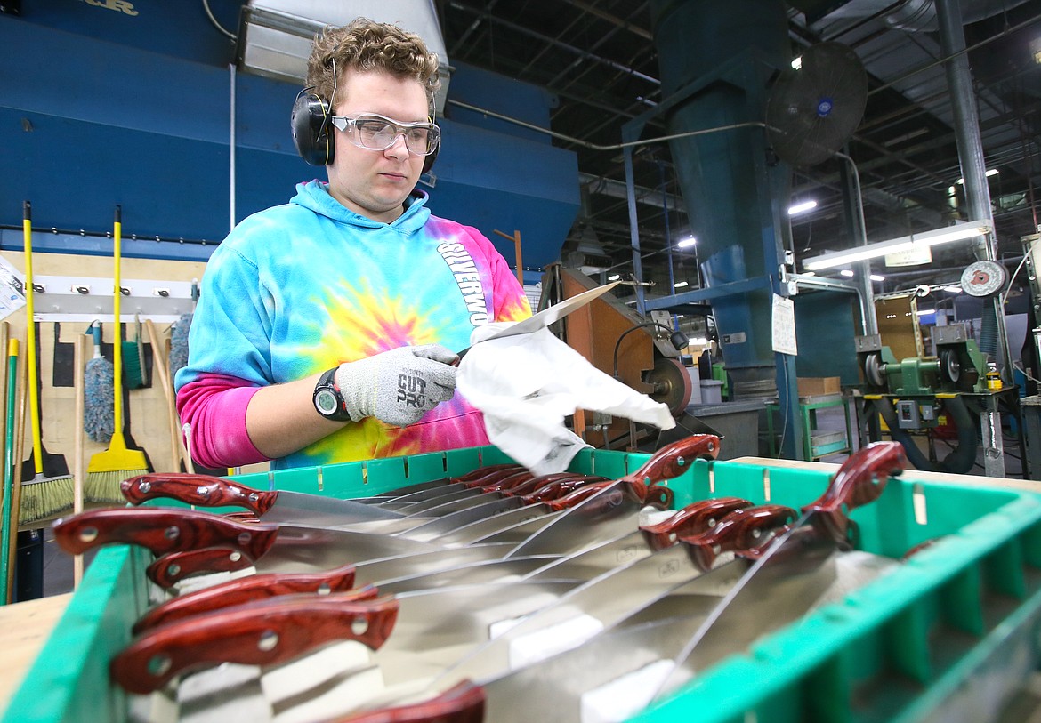 Buck Knives employee Sterling Minkler wipes down chef knives Jan. 9. The Post Falls company employs over 300 people.