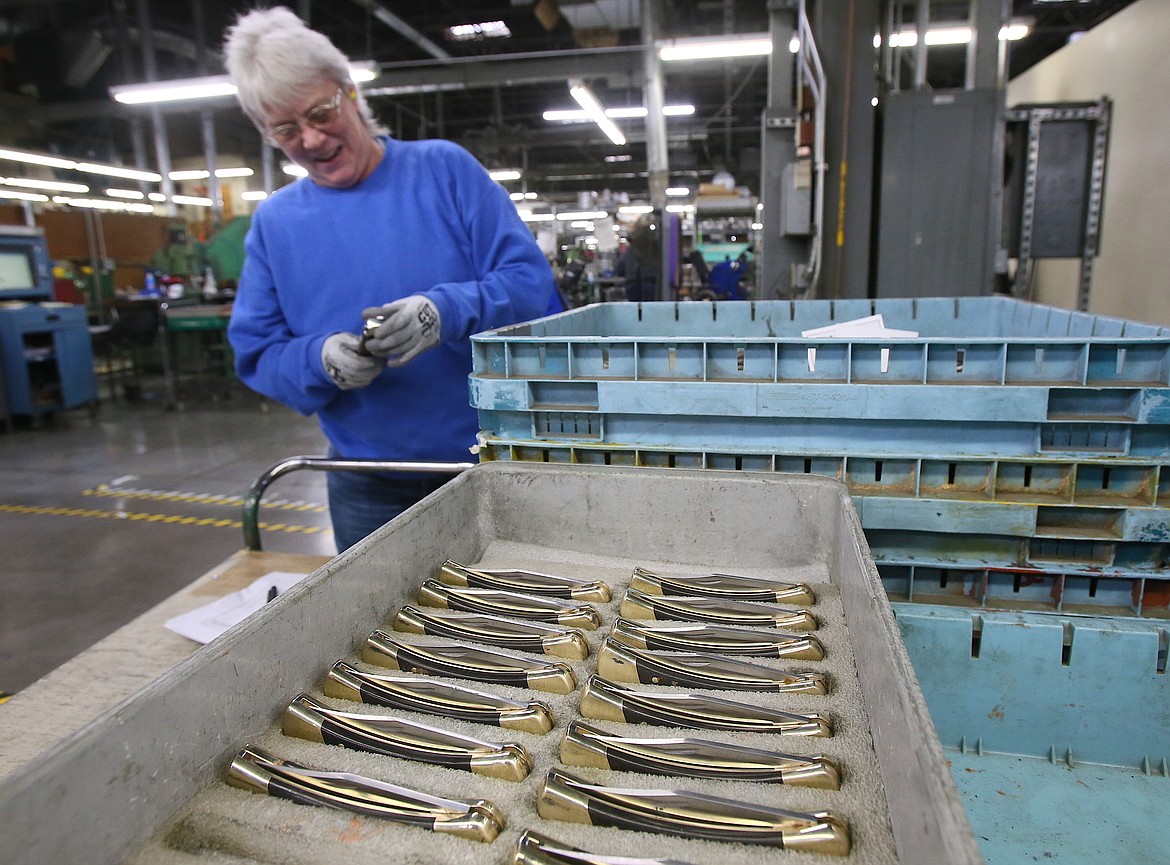 Quality inspector Kim Wendland looks over 60th anniversary Buck Knives crafted with Honduran rosewood handles.