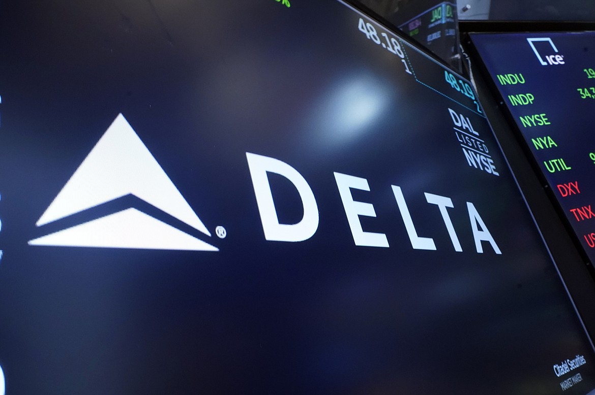 FILE - The logo for Delta Air Lines appears on a screen above a trading post, on the floor of the New York Stock Exchange, Thursday, July 13, 2023. Delta Air Lines earned $2 billion in the fourth quarter, posted record full-year revenue, and says it's buying more planes to boost its international flying. (AP Photo/Richard Drew, File)