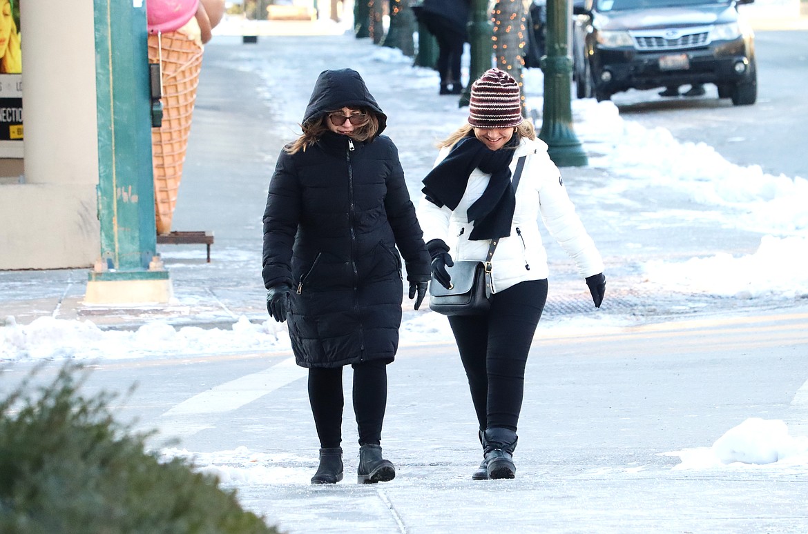 Rita Popp, left, and Colleen Delaney make their way to a Sherman Avenue coffee shop on Friday afternoon.