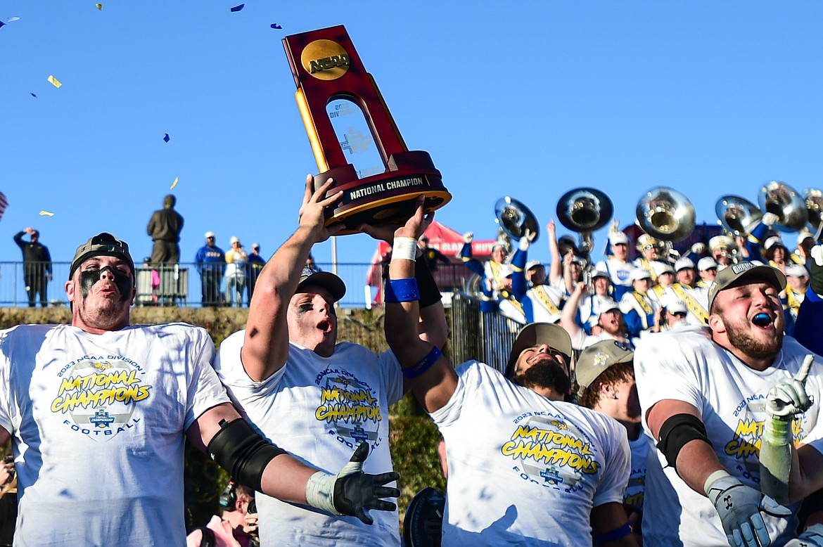 Mark Gronowski holds up the championship trophy as South Dakota State celebrates after a 23-3 win over Montana at Toyota Stadium in Frisco, Texas on Sunday, Jan. 7. (Casey Kreider/Daily Inter Lake)