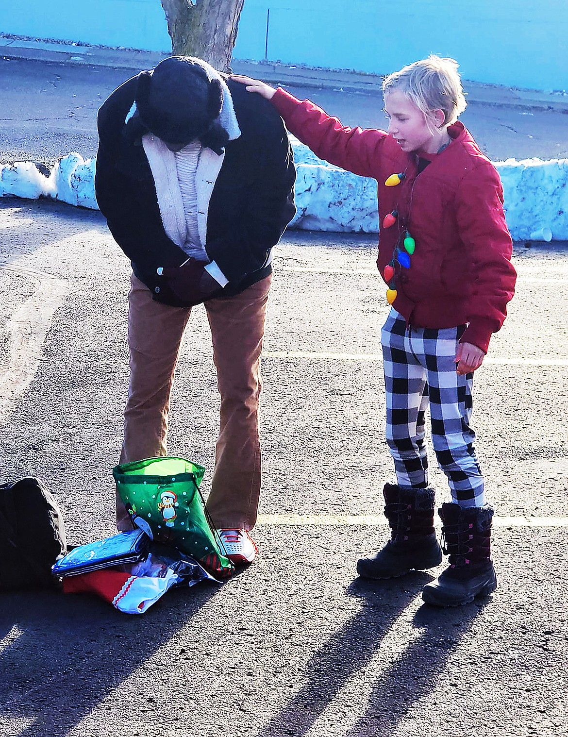 Raye Johnson offers comfort to a homeless man after handing him a Christmas backpack and stocking during this year's Raye of Hope drive.