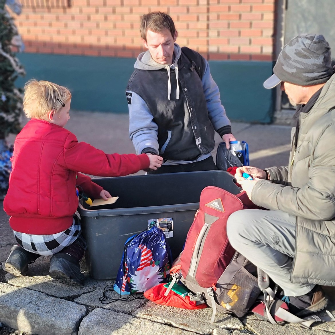 Raye Johnson talks to several homeless men while helping them pick out needed toiletries and other items during the recent Raye of Hope drive.