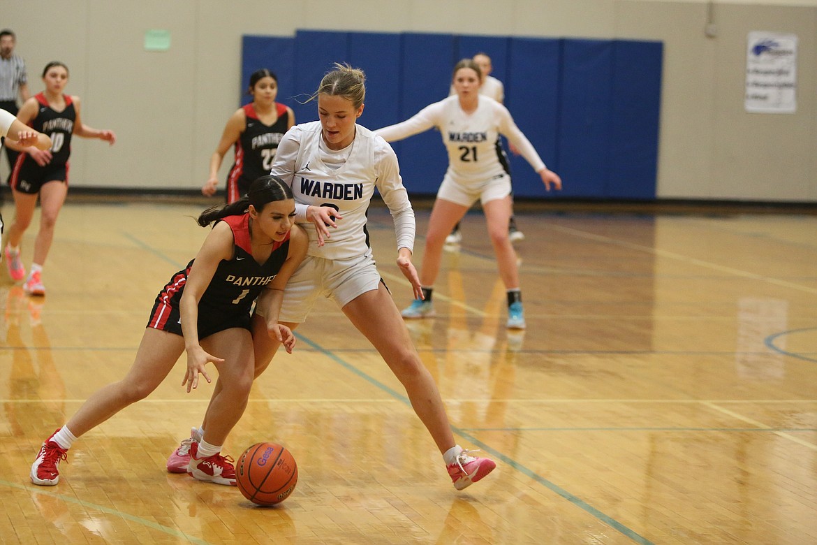 Warden senior Lauryn Madsen, in white, defends against a River View player in the first quarter of the Cougars’ 76-16 win over River View.