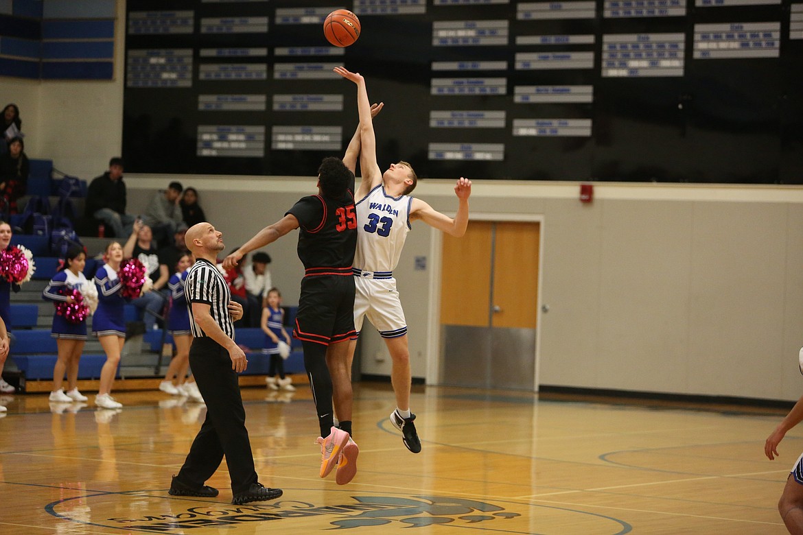 Warden junior Jake Roylance, in white, grabs the opening tipoff for the Cougars in their 74-56 win over River View.