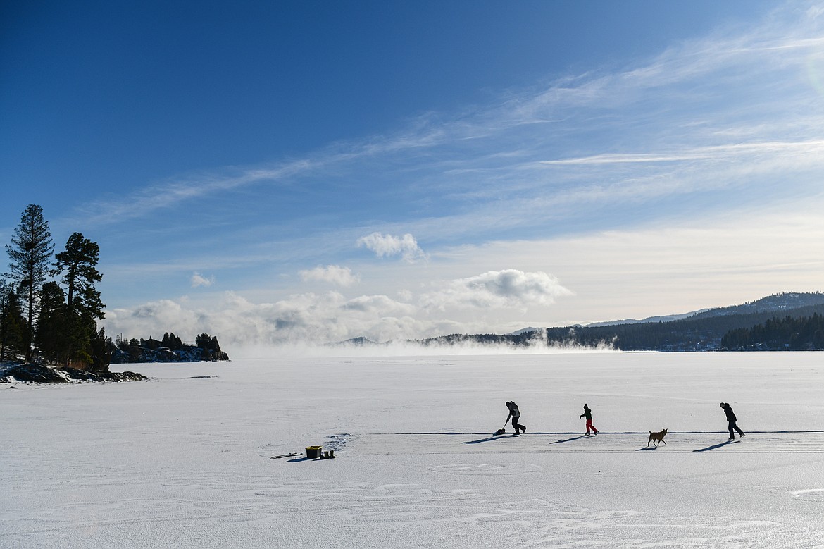 Brian, Corbin and Elizabeth Lockwood ice skate on the frozen surface of Flathead Lake's Somers Bay with their dog Willow on Saturday, Jan. 13. (Casey Kreider/Daily Inter Lake)