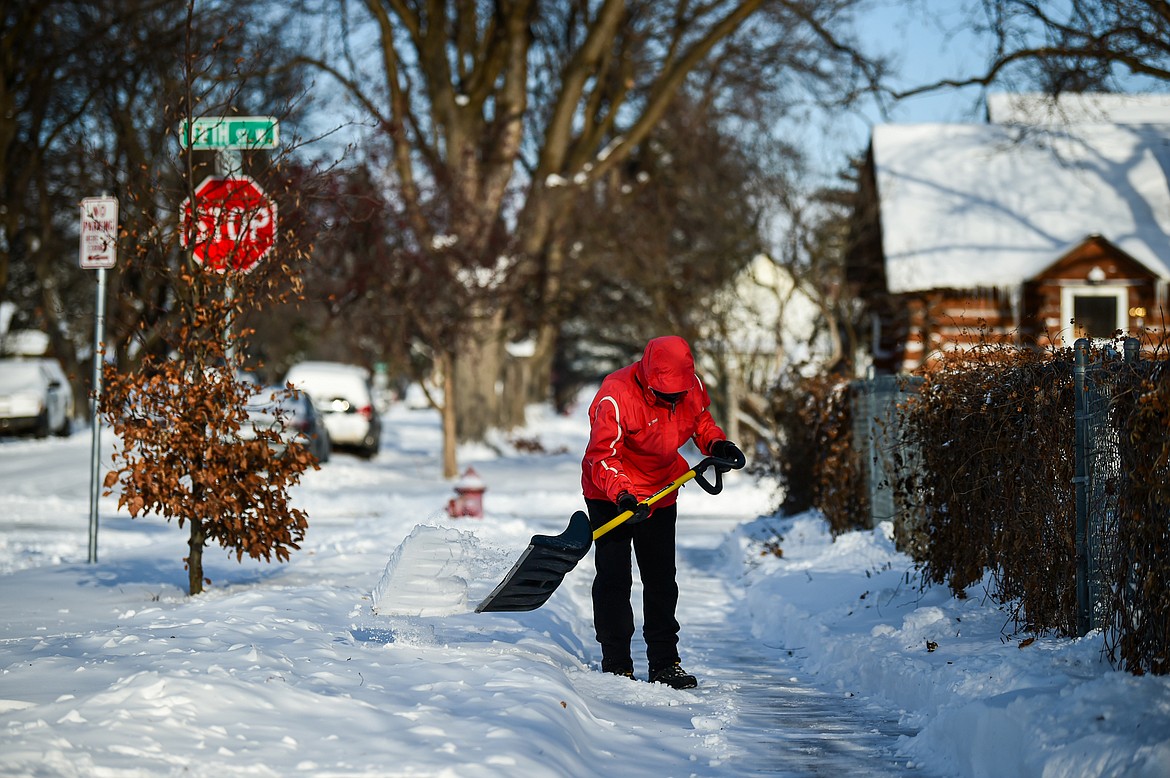 Mary Anne Miller clears snow from the sidewalks around her neighbors' residences with her friend and neighbor Jay Dundas at Sixth Avenue West and Fifth Street West in Kalispell on Friday, Jan. 12. (Casey Kreider/Daily Inter Lake)