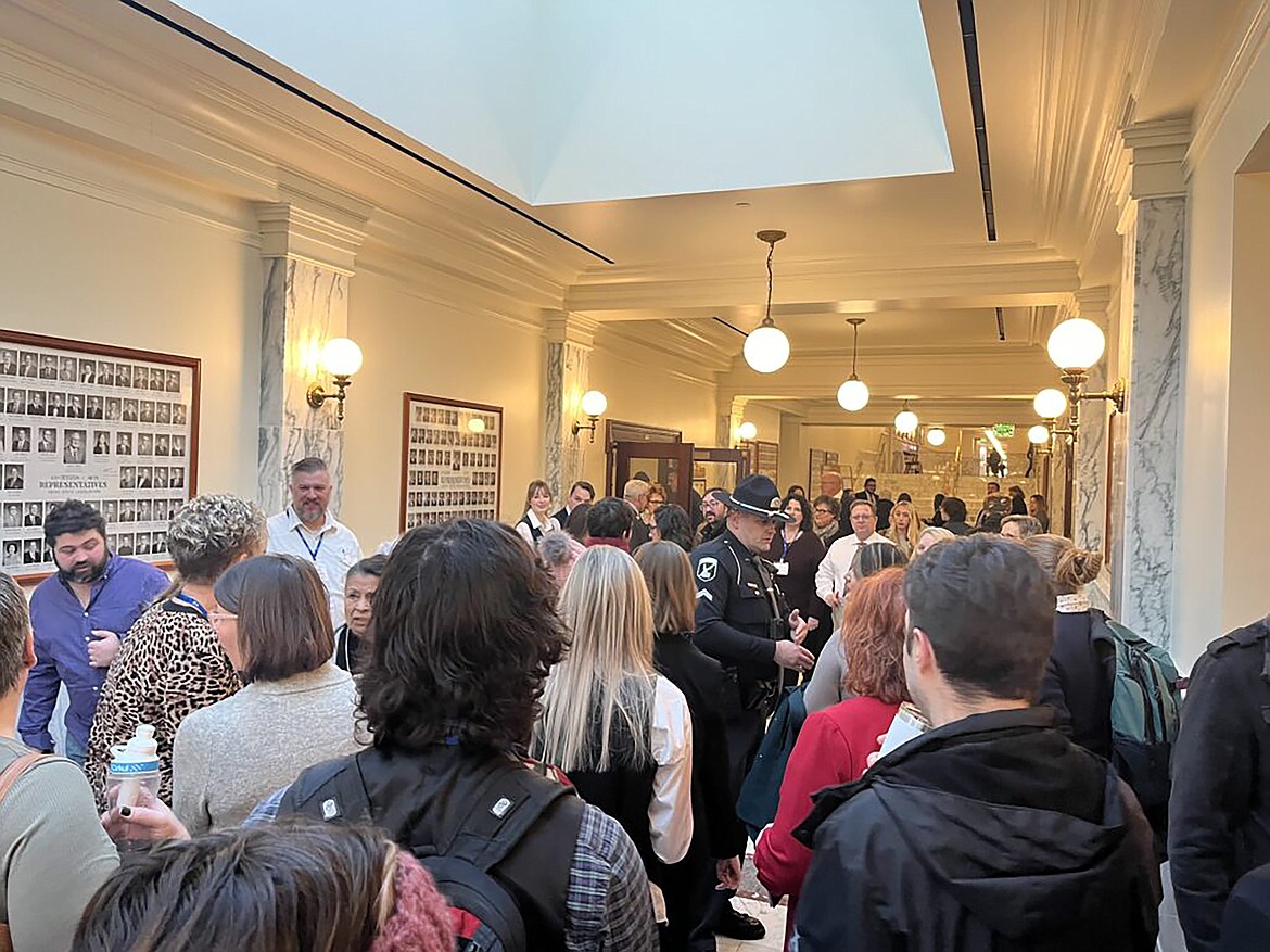 Dozens of people wait outside a committee room on Jan. 15, 2023, at the Idaho State Capitol in Boise shortly before a public hearing on a library materials bill.