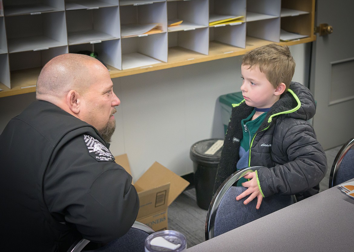 Plains Police Chief Brian Josephson answering questions from 4-year-old Brody Lane. (Tracy Scott/Valley Press)