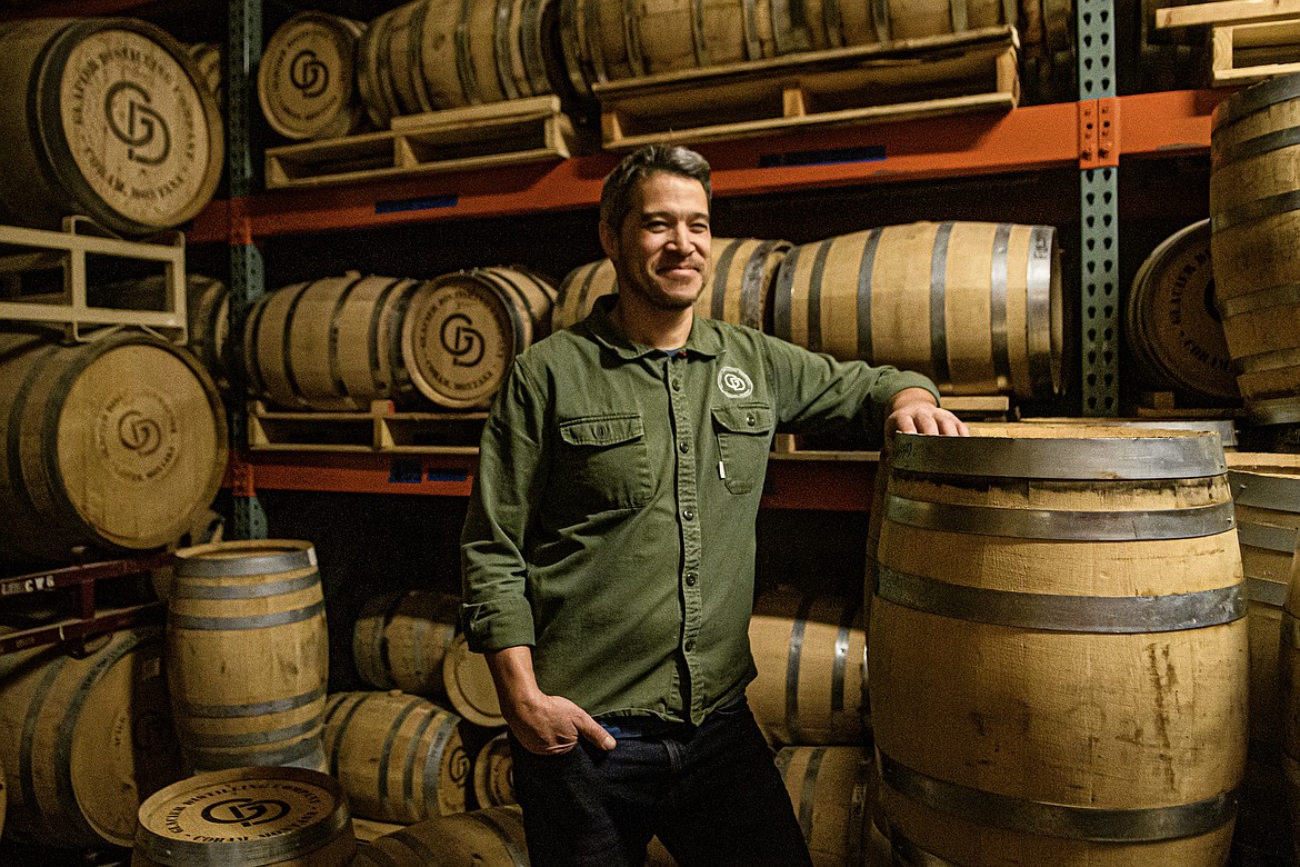 Nic Lee, Owner of Glacier Distilling Company, poses in the store room on Tuesday, Jan. 9. Lee estimated there were a couple hundred barrels in this storage space alone, which the company will pull from to use in their spirits. (Avery Howe photo)