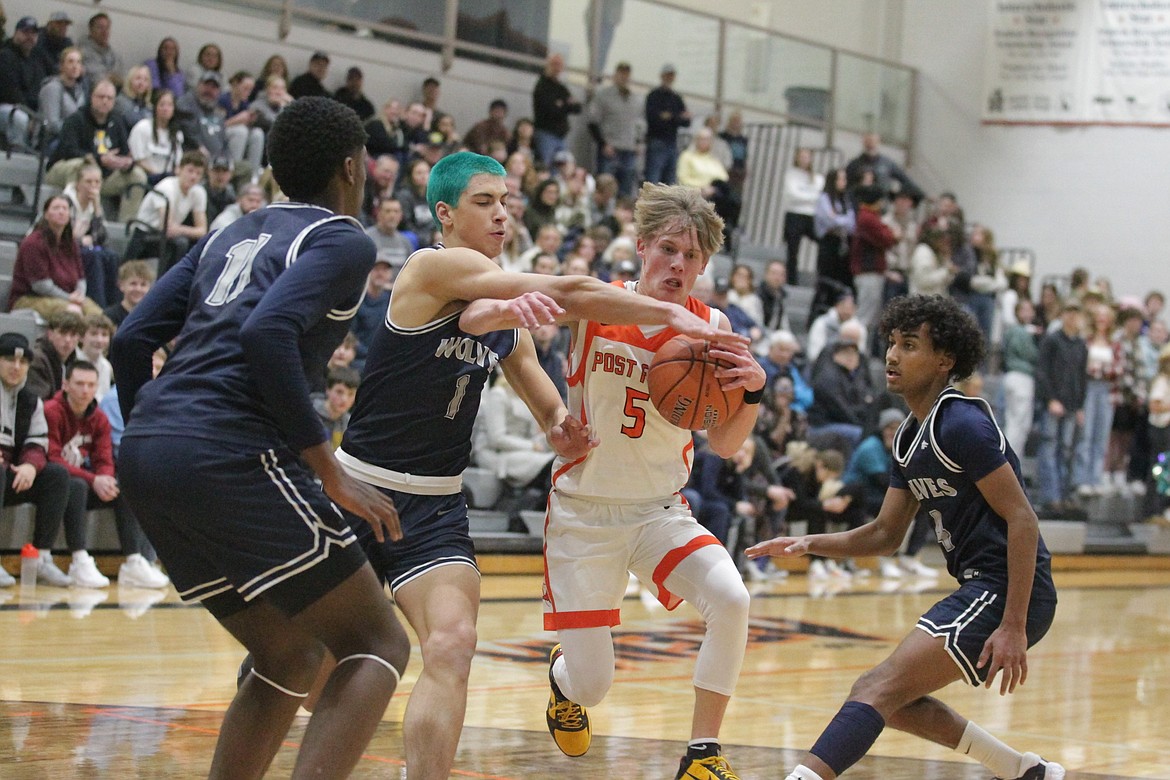 MARK NELKE/Press
Neil McCarthy (5) of Post Falls drives to the basket as Josh Watson, left, Shane Parker (1) and Cason Miller (4) of Lake City defend on Tuesday night at Post Falls.