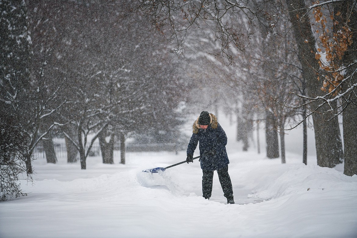 Khenda Beebe shovels snow from the sidewalk in front of her residence along Fourth Avenue East during a snowstorm on Wednesday, Jan. 17. (Casey Kreider/Daily Inter Lake)