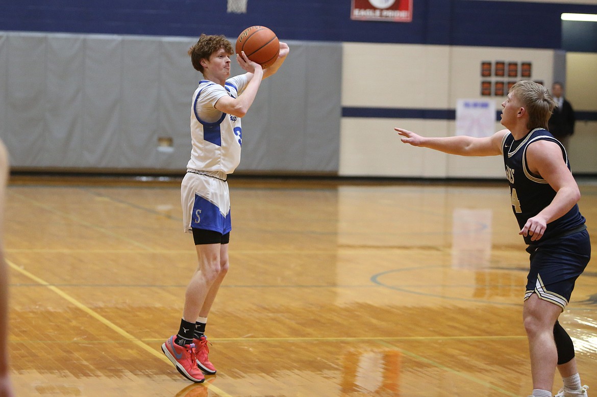 Soap Lake senior Trey Landdeck, in white, attempts a three-pointer in the first quarter against MLCA/CCS.