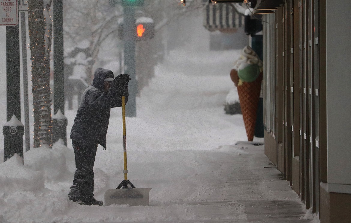 Kayla Brazeau with The Coeur d’Alene Resort leans on her shovel as she takes a quick break from clearing the sidewalk on Sherman Avenue in front of Tito’s Italian Grill and Wine Shop on Wednesday