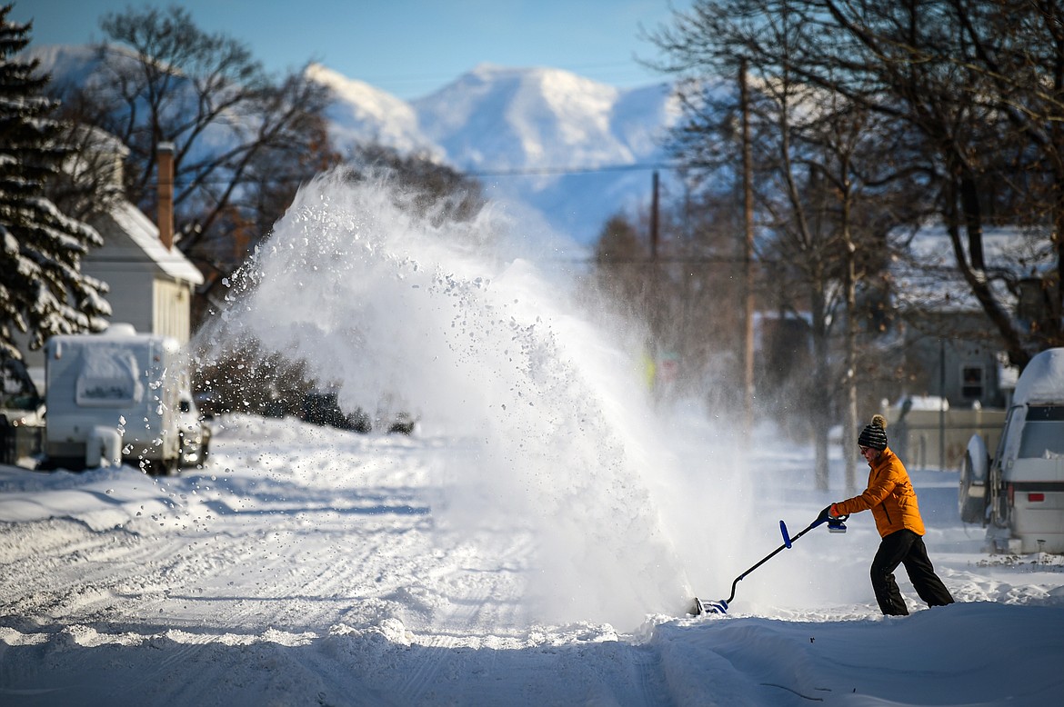 Rhonda Stephens clears snow around her residence along Fourth Street West on Thursday, Jan. 18. (Casey Kreider/Daily Inter Lake)