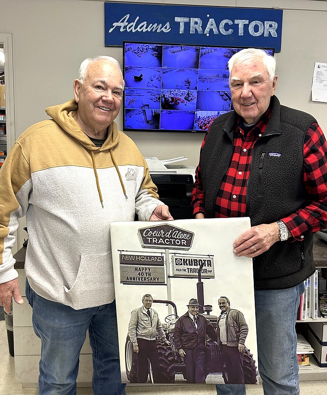 Wally Adams, left, and John Adams hold a picture of themselves with their father, Jack Adams.