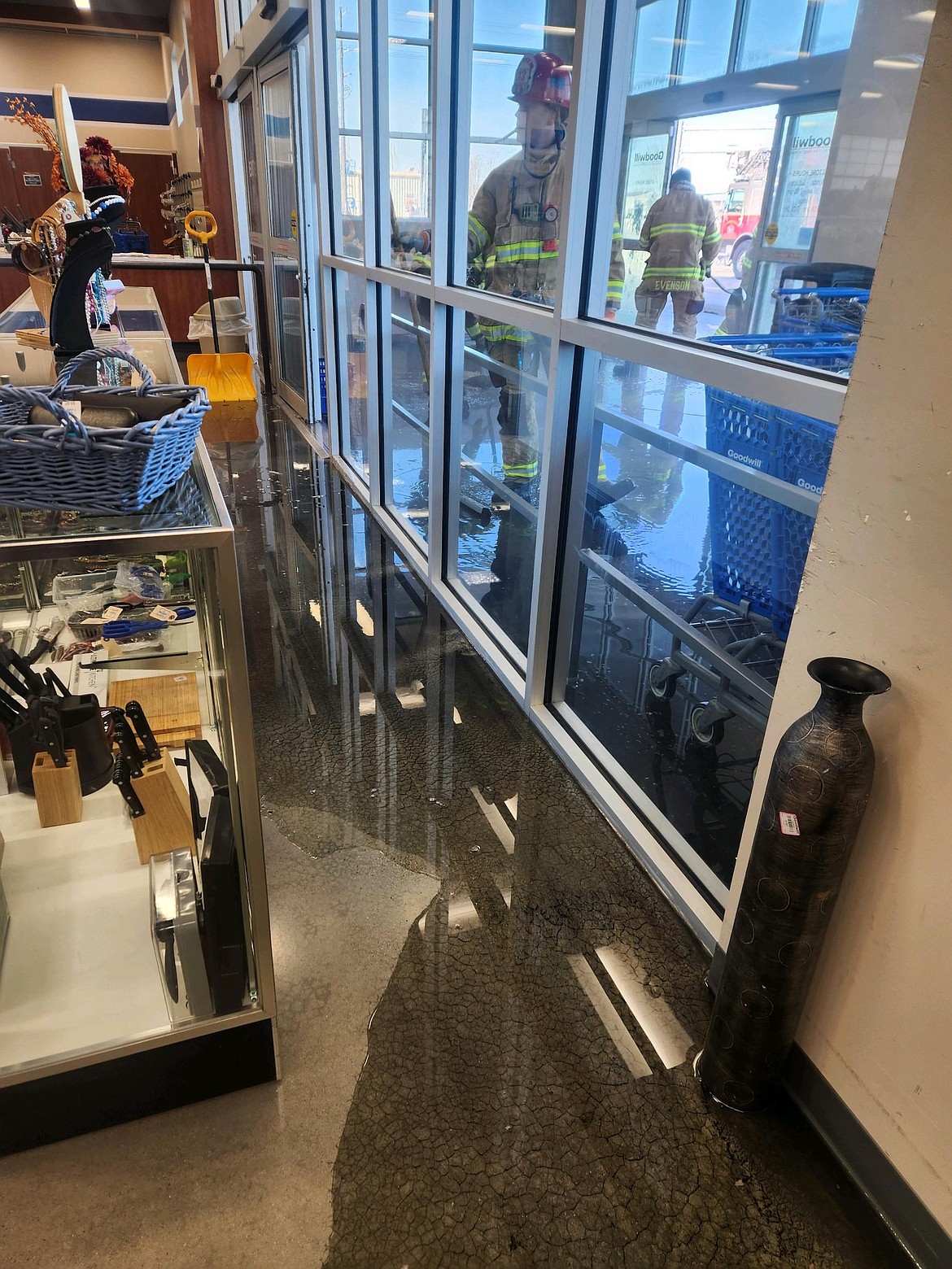 Kootenai County Fire and Rescue crew members work in the entryway of the Post Falls Goodwill as water seeps into the store Saturday, Jan. 13. The store was closed until Wednesday as crews worked to mitigate water damage caused by burst pipes. Repairs will continue into next week.