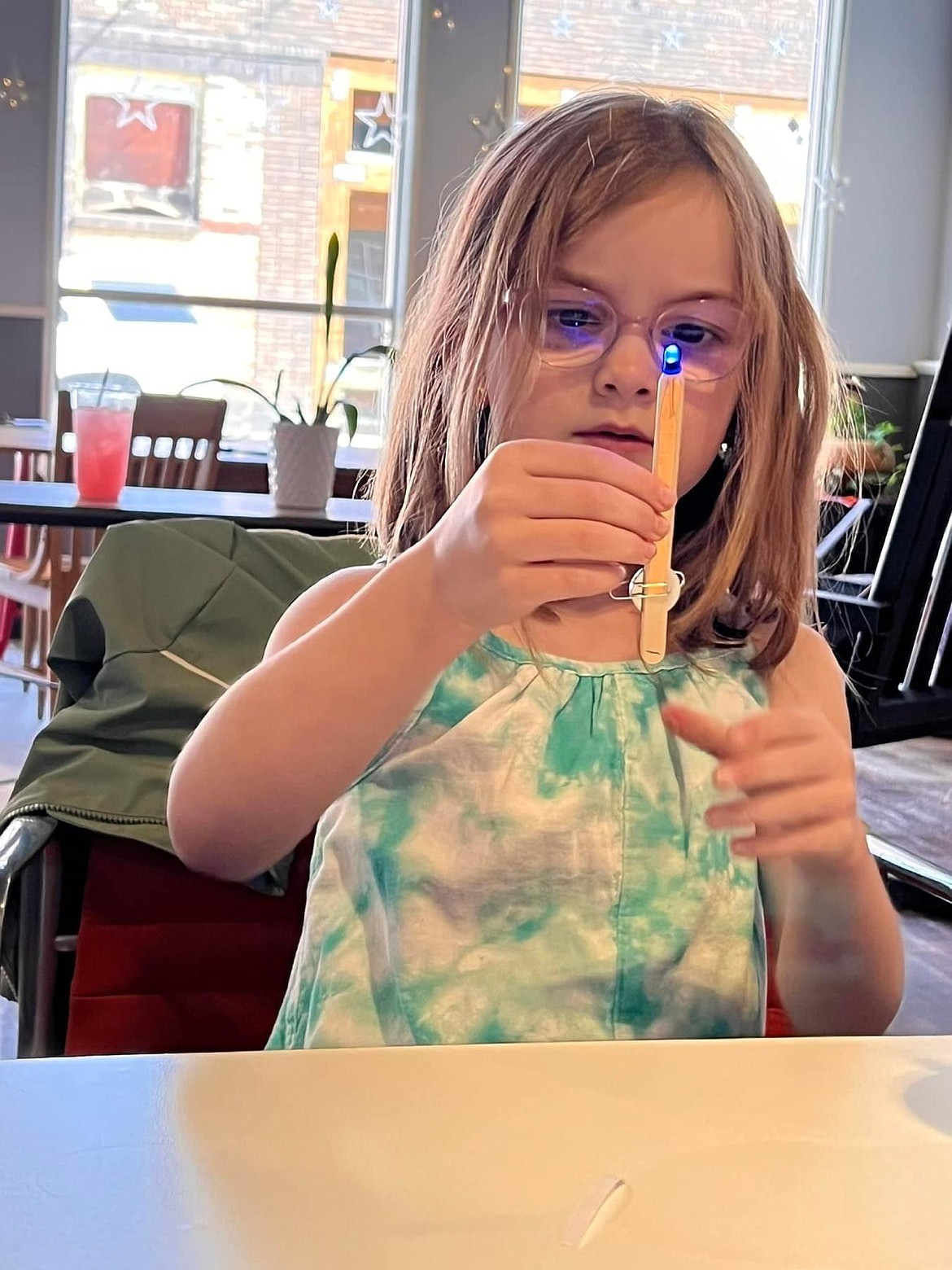 Hadalynn Olsen holds up a copper tape battery that she created during a STEM workshop.