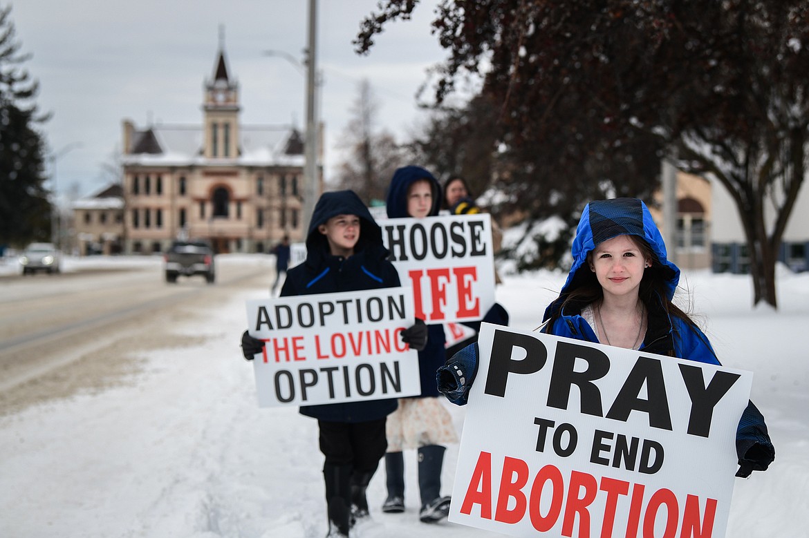 Participants hold signs and walk along South Main Street during the Flathead ProLife 41st annual Rally and March For Life in Kalipsell on Saturday, Jan. 20. (Casey Kreider/Daily Inter Lake)