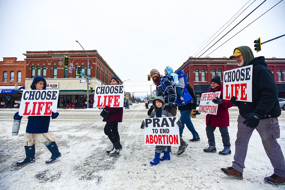 Participants hold signs and walk along South Main Street during the Flathead ProLife 41st annual Rally and March For Life in Kalipsell on Saturday, Jan. 20. (Casey Kreider/Daily Inter Lake)