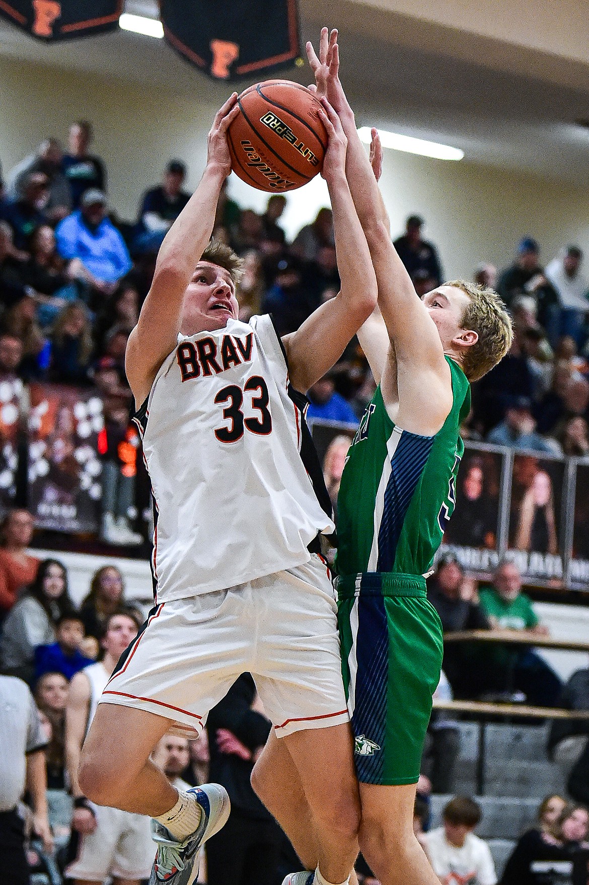 Flathead's Korbin Eaton (33) drives to the basket guarded by Glacier's Easton Kauffman (5) in the second half at Flathead High School on Friday, Jan. 19. (Casey Kreider/Daily Inter Lake)